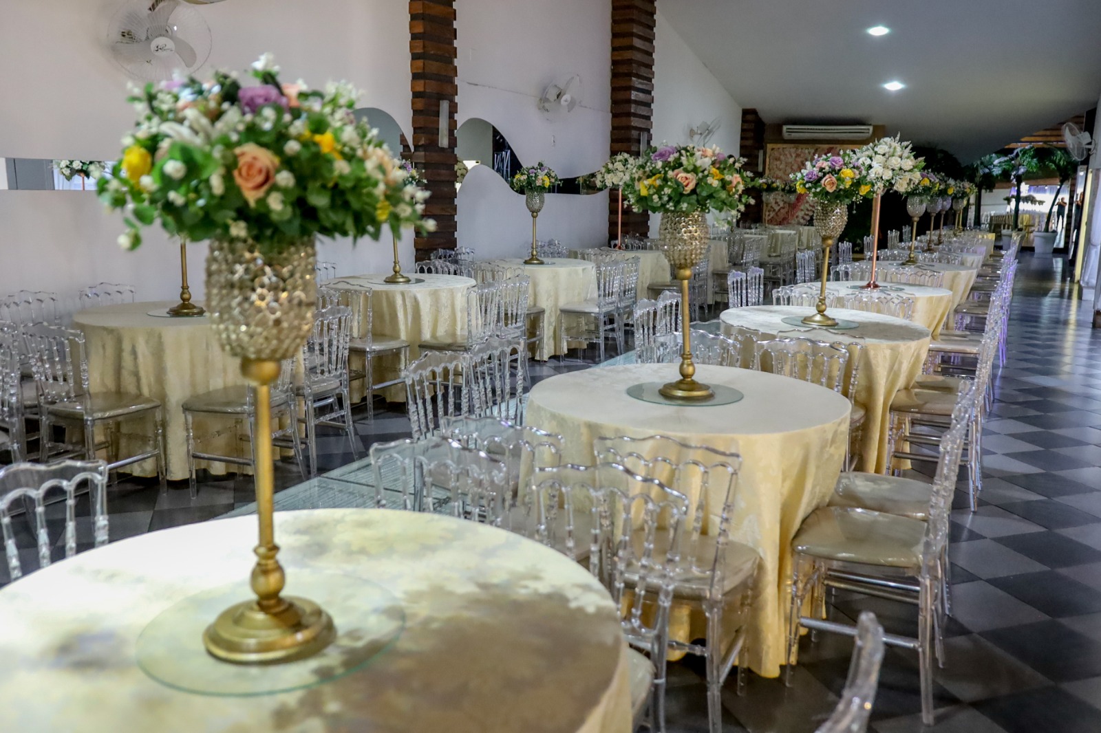 Salão montado em tons claros com arranjos florais